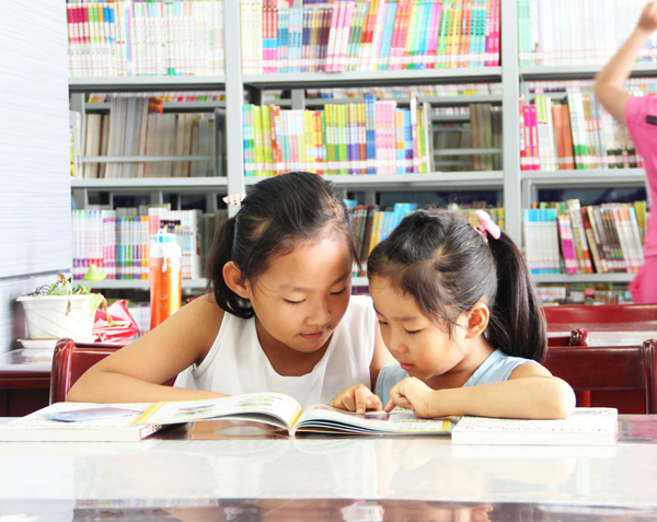 两个小朋友正在垦利县图书馆看书 王倩 摄