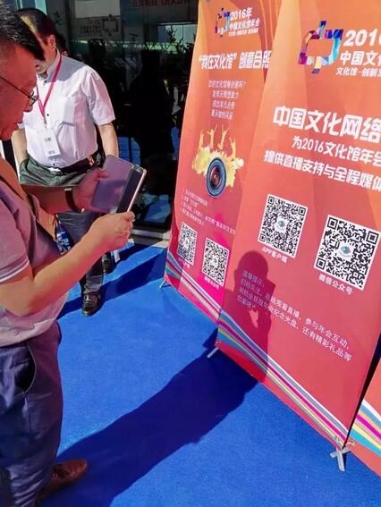 图为现场观众在扫码参与中国文化网络电视年会互动活动