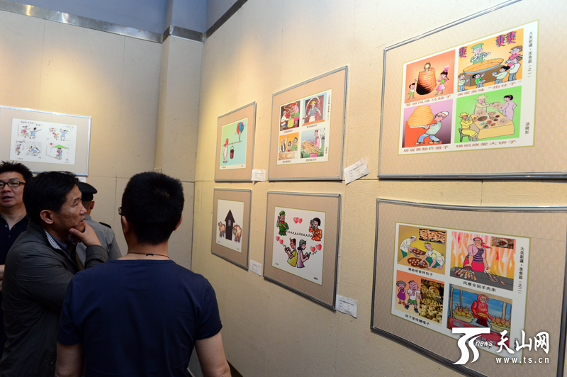 “新疆新闻漫画作品展”在乌鲁木齐文化馆开展,市民参观展览。